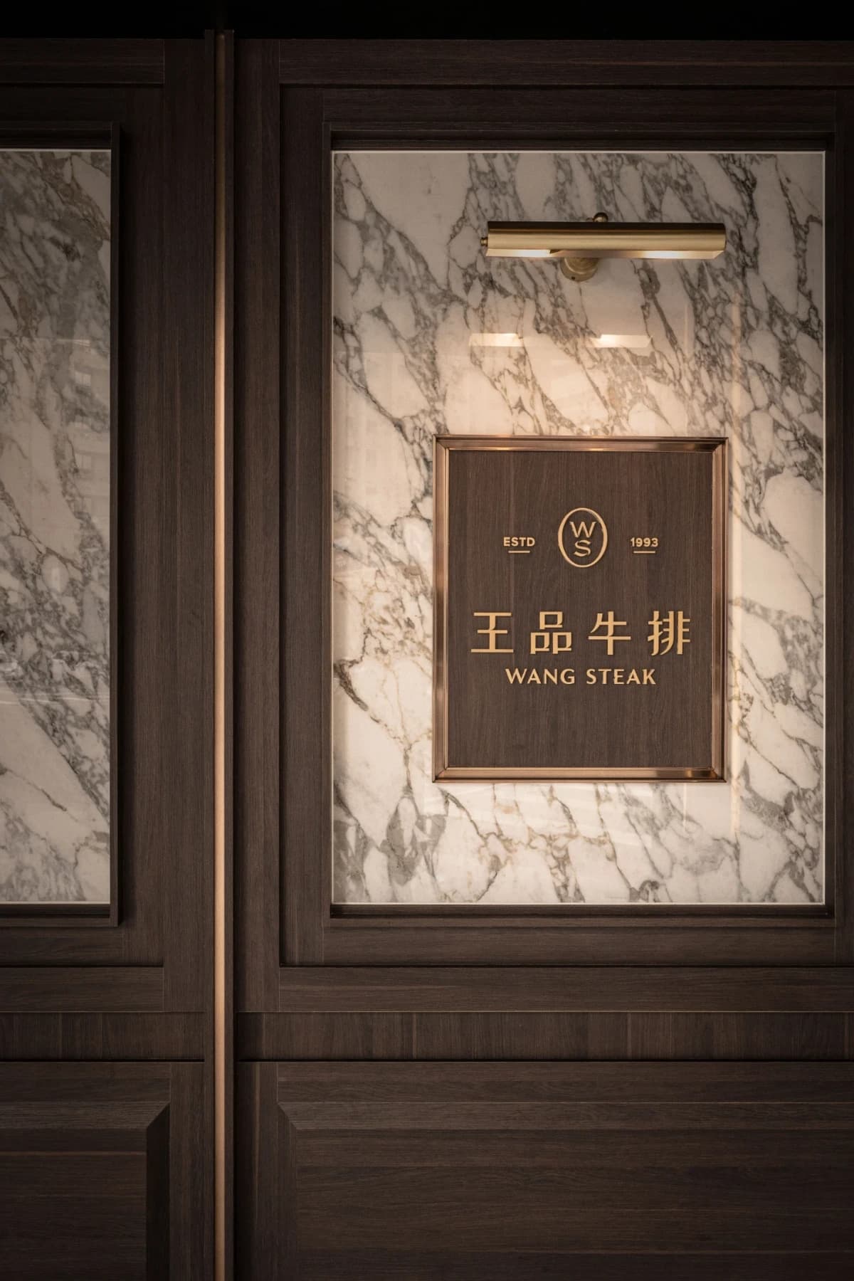 街邊店外觀透過品牌色彩與材質沉穩煙燻木皮與白色大理石紋層次建立高辨識度門面形象