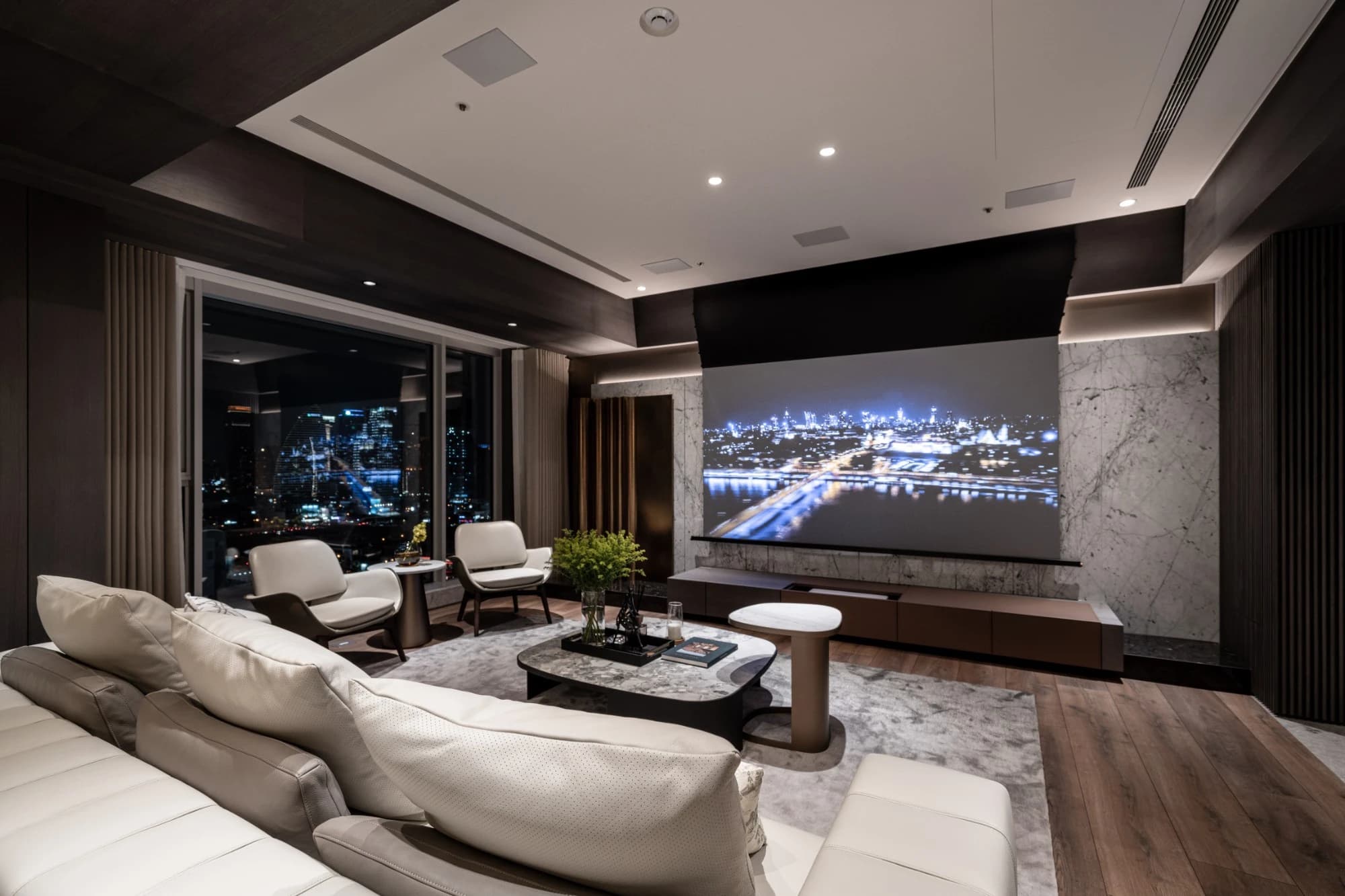 台中七期豪宅，寶輝 CITY PARK Y Residence 客廳夜景，現代豪邸大理石V-Cut工藝，與波浪曲面金屬牆，採用投影幕無電視設計。